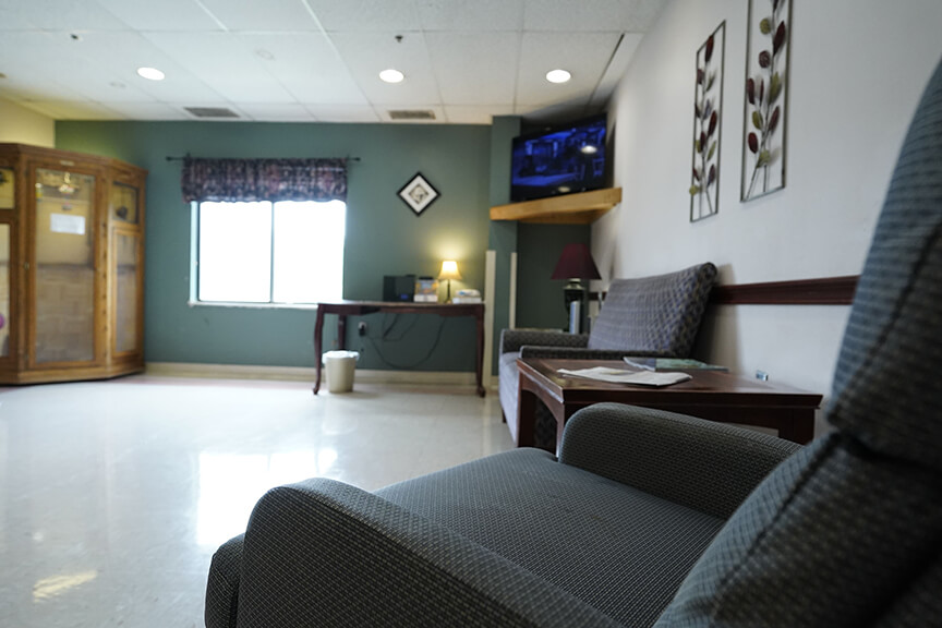 Sofa with table and television in Resident Lounge- Arbors at Marietta
